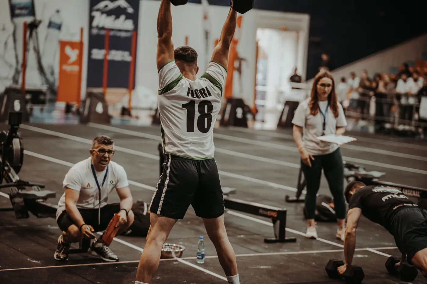 Atleta compitiendo ante el juez y el público en un evento deportivo